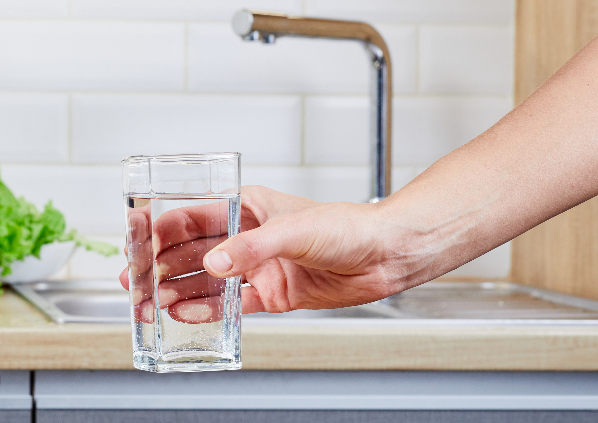 vaso de agua con grifo de osmosis inversa detrás