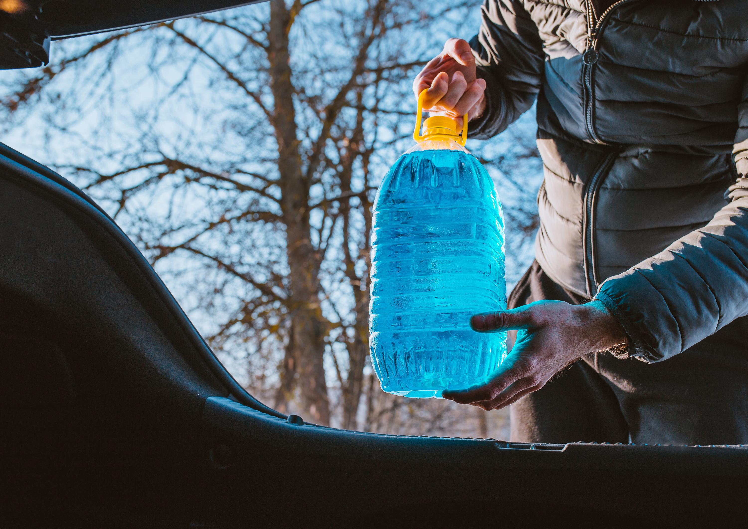 Persona cargando agua embotellada en el coche