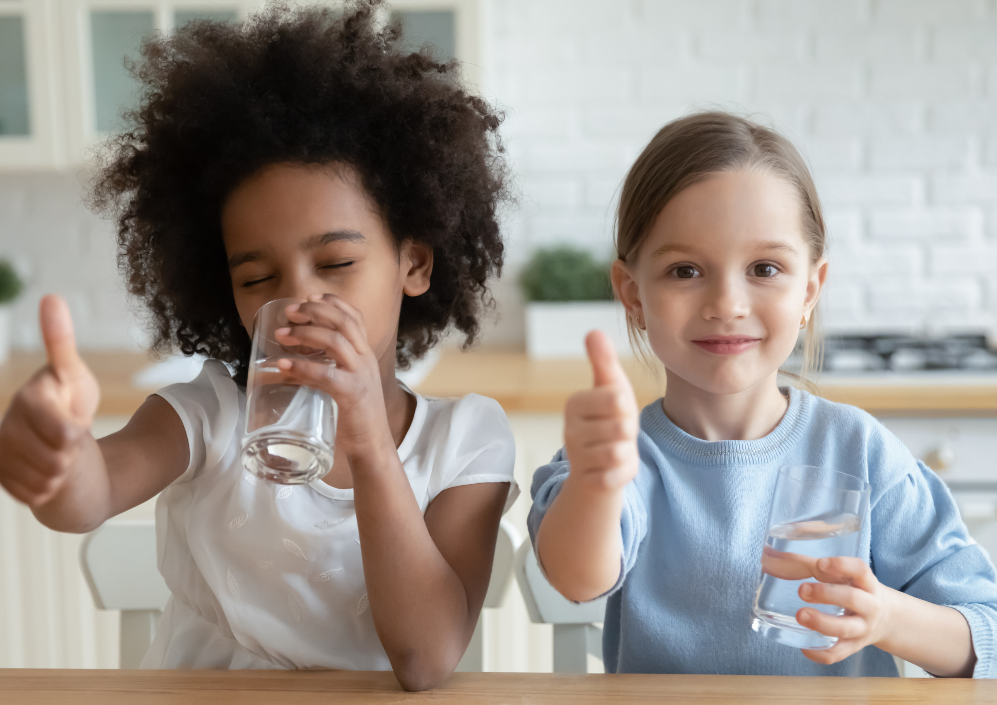 Niñas bebiendo agua de osmosis en casa